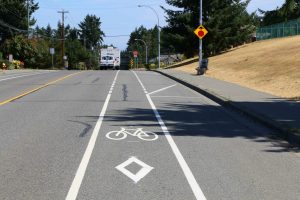 Bicycle lane approaching a 4 way stop intersection. Note that the bicycle lane is separated from the traffic lanes by solid white line and dashed white lines. Motor vehicle traffic can cross the bicycle lane at the dashed white lines but not on the solid white lines. (photo by WestCoastDriverTraining.com)