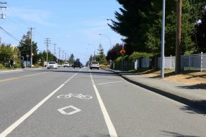 Bicycle lane approaching a 4 way stop intersection. Note that the bicycle lane is separated from the traffic lanes by solid white line and dashed white lines. Motor vehicle traffic can cross the bicycle lane at the dashed white lines but not on the solid white lines. (photo by WestCoastDriverTraining.com)