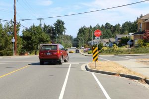 Bicycle lane at a 4 way stop intersection. Note that there is a solid white line separating the bicycle lane from the traffic lane. This car is making the right turn from the proper position to the left of the bicycle lane. (photo by WestCoastDriverTraining.com)