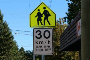 School Zone sign (Advisory) with regulatory sign attached for posted 30 km/h speed limit. Note that this sign contains hours the School Zones is in effect, in this case 8:00 a.m. to 5 p.m. on School Days (photo by WestCoastDriverTraining.com)