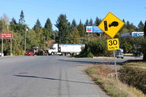 Advisory sign warning of trucks entering the highway from the right, in this case from a commercial vehicle fueling station. Note the advisory speed of 30 km/h (photo by WestCoastDriverTraining.com)