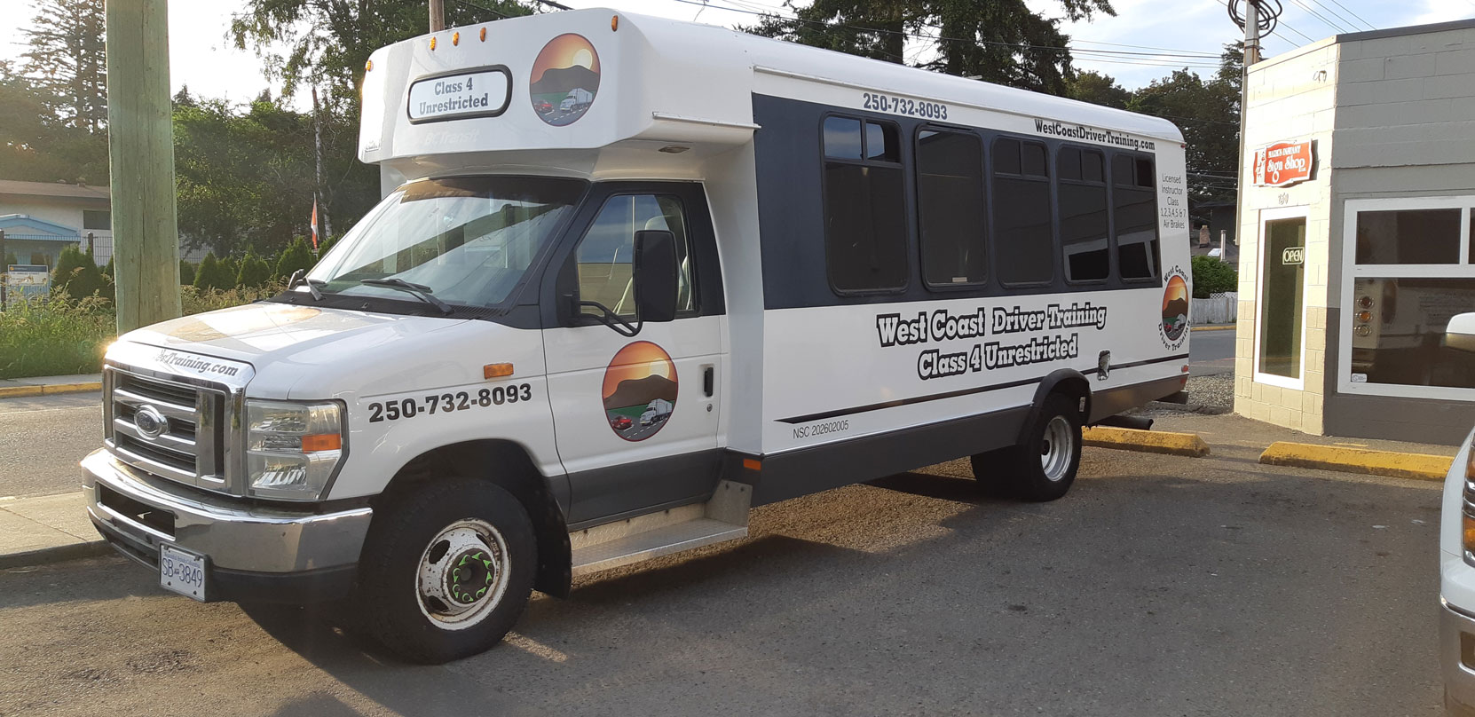 Our Ford E450 20 seat bus at Mark's Instant Sign Shop after application of its final signage [Photo: West Coast Driver Training]