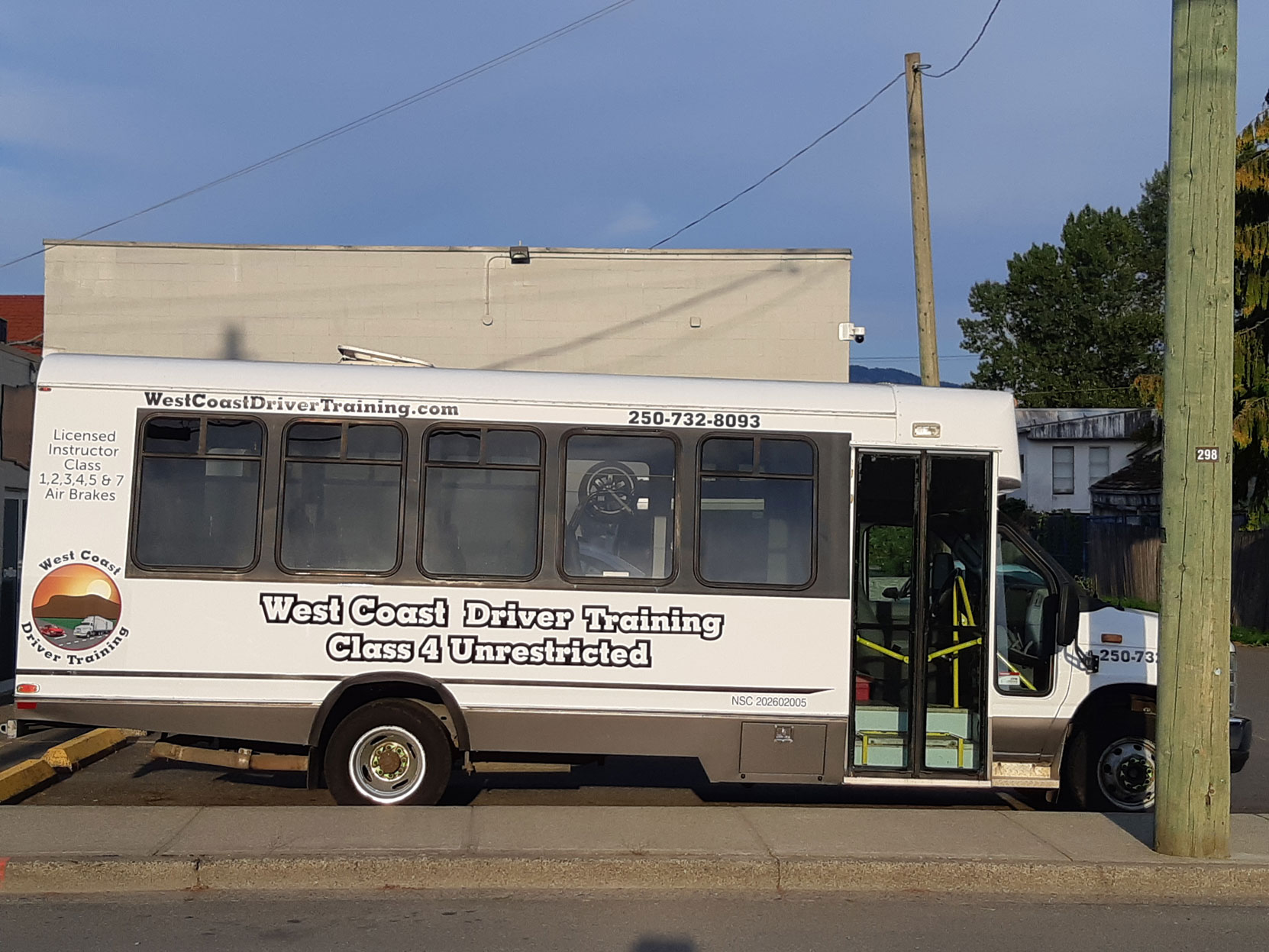 Our Ford E450 20 seat bus at Mark's Instant Sign Shop after application of its final signage [Photo: West Coast Driver Training]