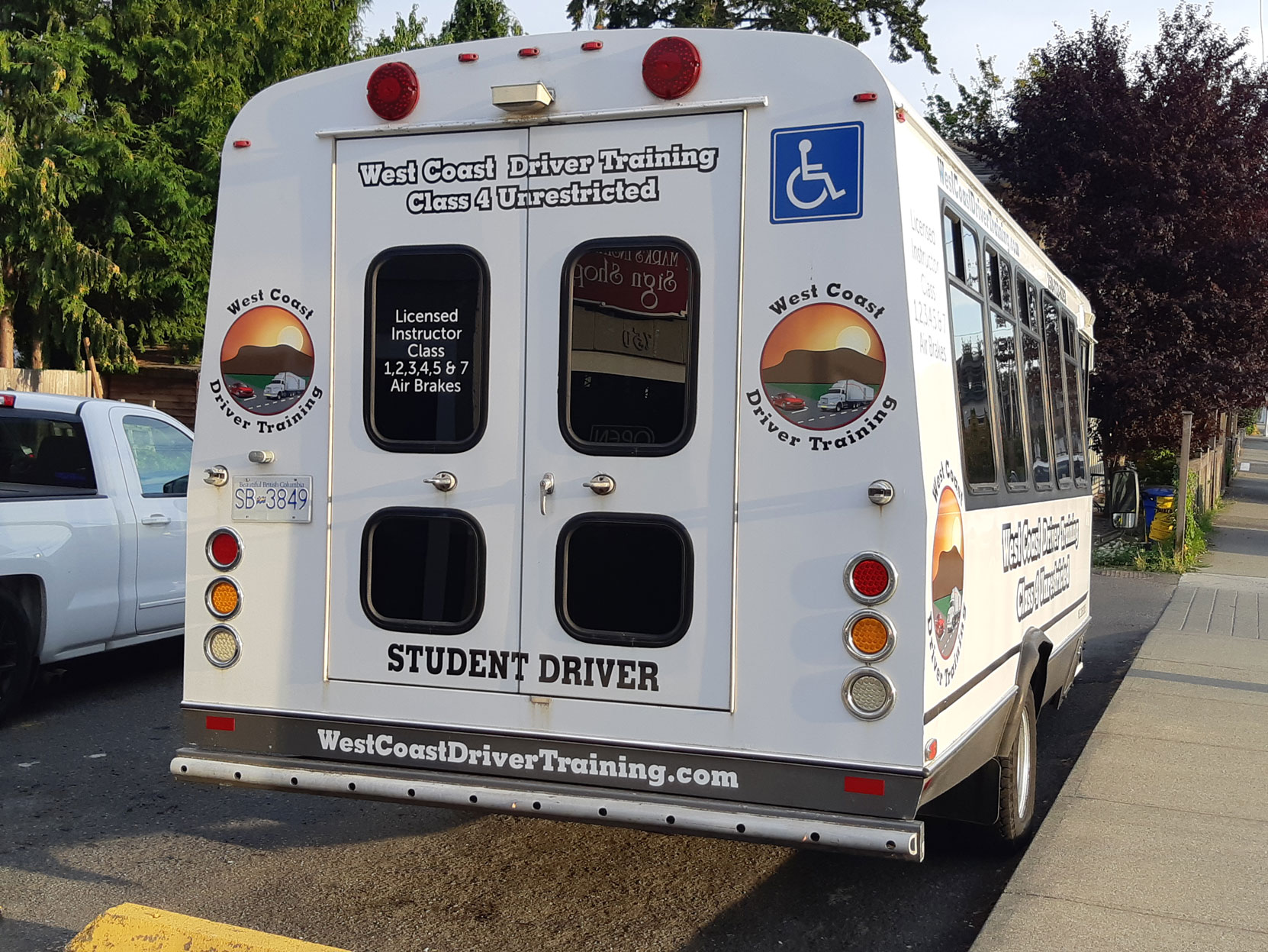 Our Ford E450 20 seat bus at Mark's Instant Sign Shop after application of its final signage [Photo: West Coast Driver Training]